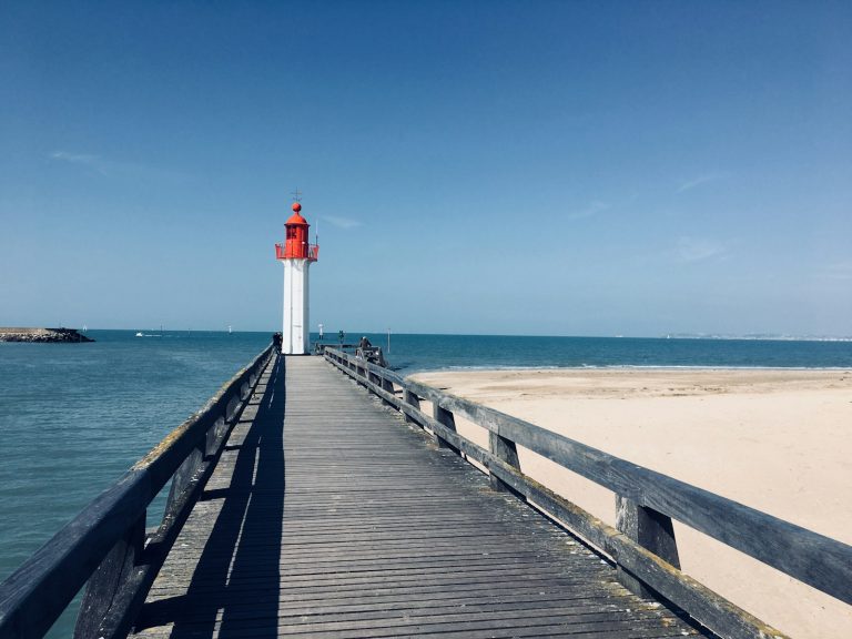 wooden footbridge leading to lighthouse by the sea