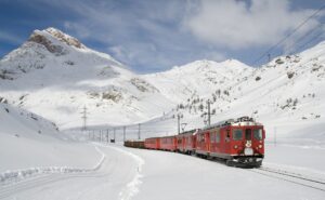 train rouge en Suisse dans les montagnes pour illustrer le voyage bas carbone