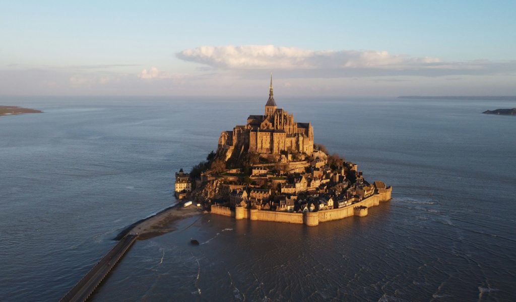 a castle on a small island with Mont Saint-Michel in the background
